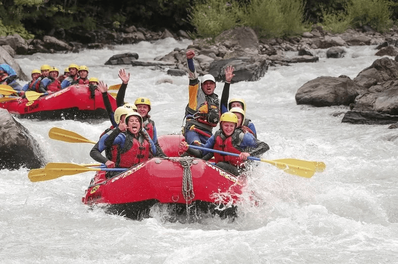 Rafting adventure on the Lutschine with participants in red boats.