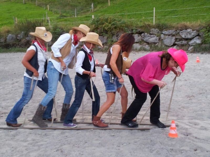 Aelplerolympics 2023: Team competition with participants in traditional clothing on a sand court.